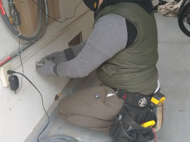Electrician performing outlet wiring in a Terre du Lac garage